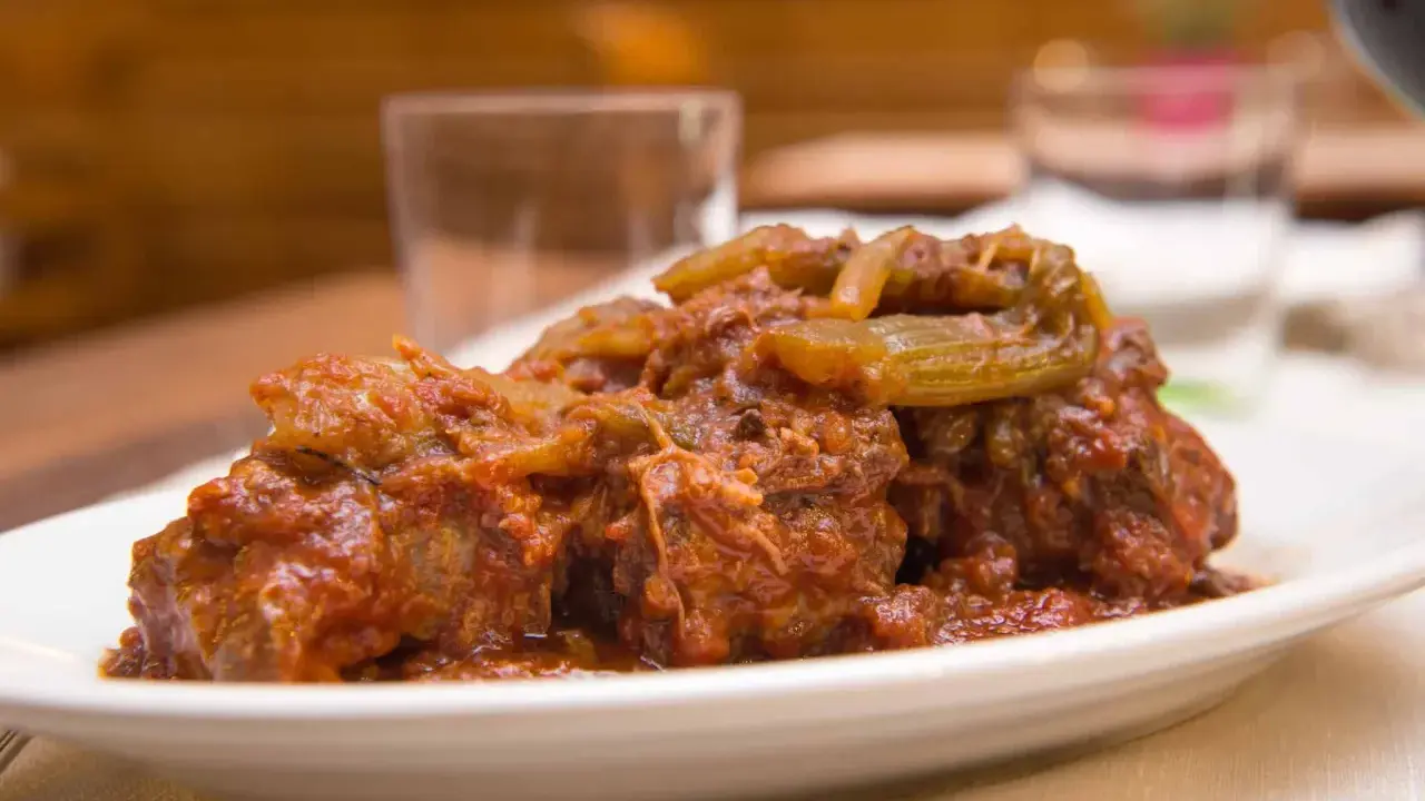 Un succulento piatto di coda alla vaccinara, cotta lentamente in un ricco sugo di pomodoro con verdure.