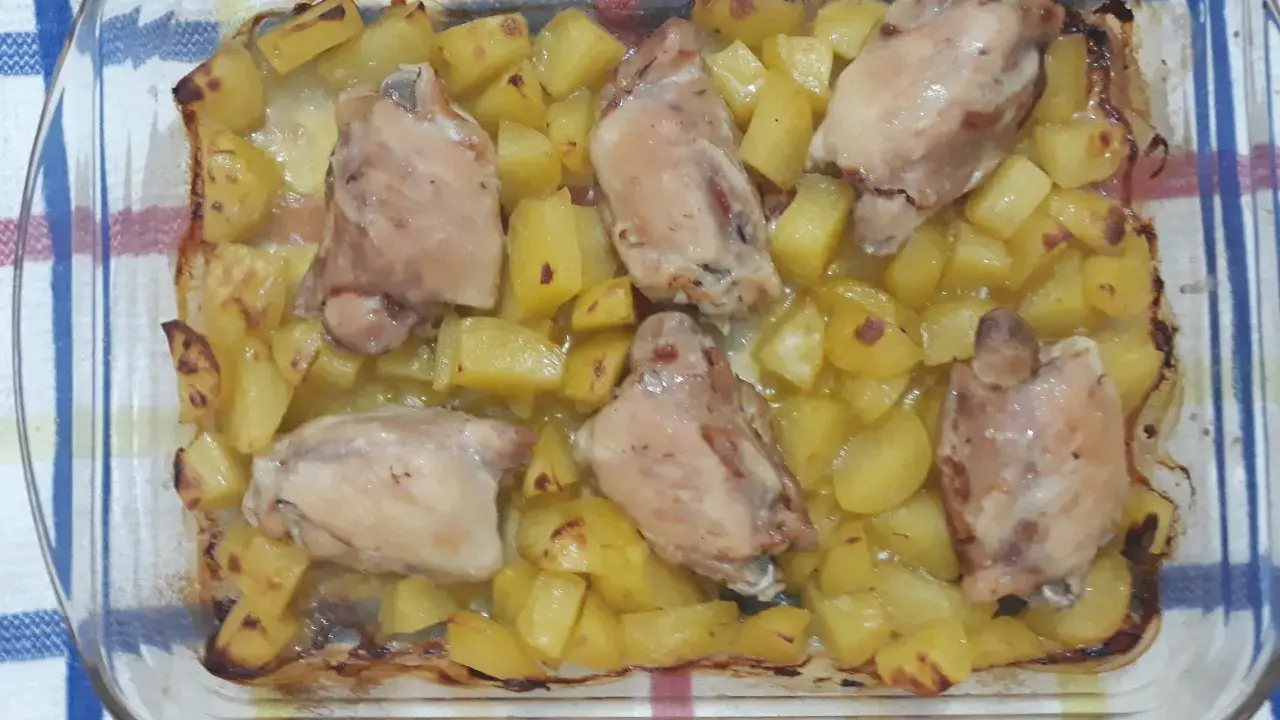 Sovracosce di pollo al forno con patate dorate, un piatto succulento e profumato, pronto per essere gustato.