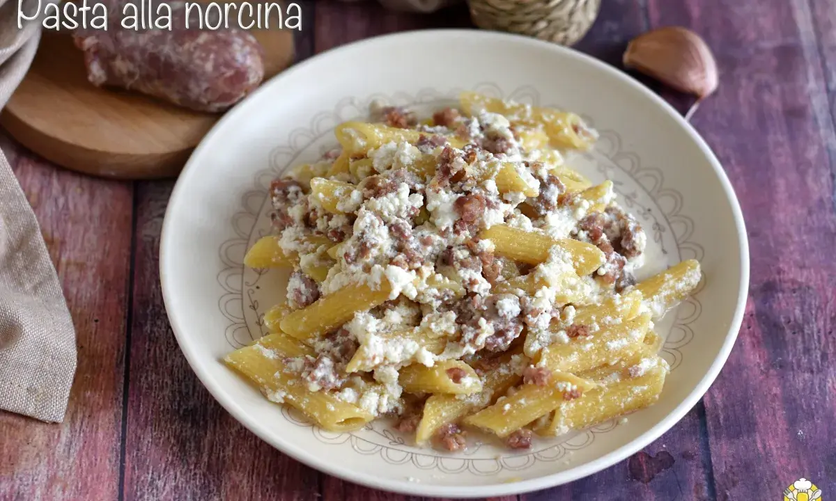Piatto di pasta alla norcina con salsiccia sbriciolata e ricotta cremosa, un classico della cucina umbra.