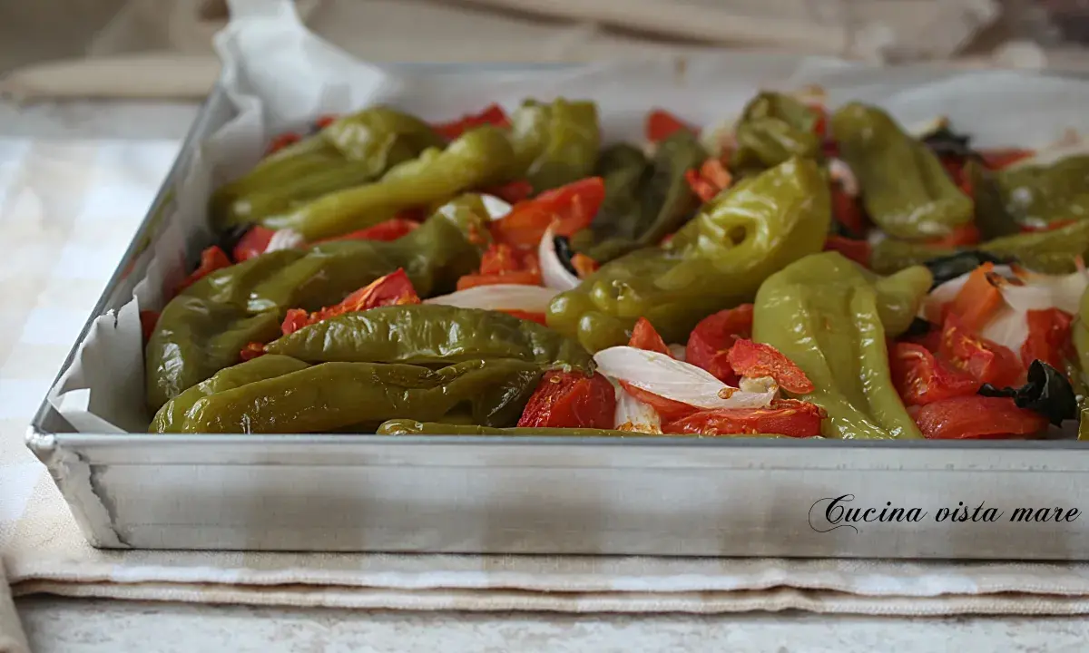 Friggitelli al forno con pomodori e cipolla, pronti per essere gustati.
