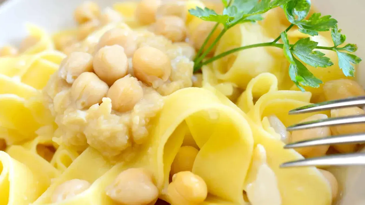 Piatto di ciceri e tria, pasta fresca con ceci cremosi e un rametto di prezzemolo.