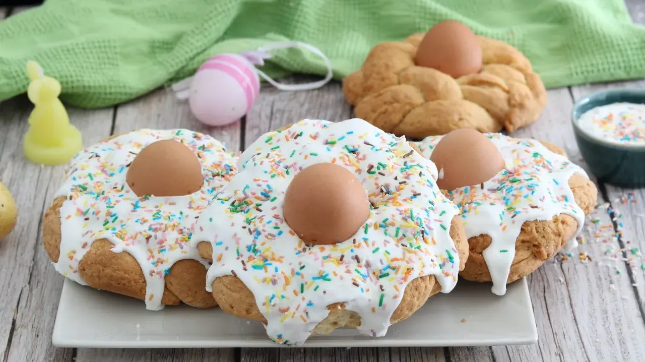 Scarcelle fatte in casa da Benedetta, decorate con glassa bianca, zuccherini colorati e uova sode, pronte per la Pasqua.