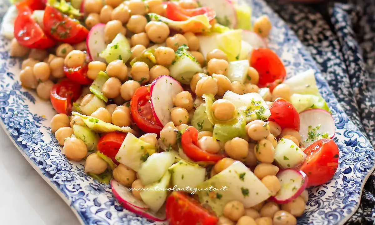Un'appetitosa insalata di ceci con pomodorini, cetrioli e ravanelli, condita con erbe fresche.