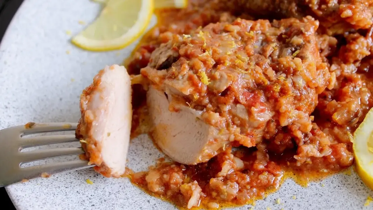 Un saporito ossobuco di tacchino in umido con pomodoro e riso, guarnito con scorza di limone e spicchi freschi.