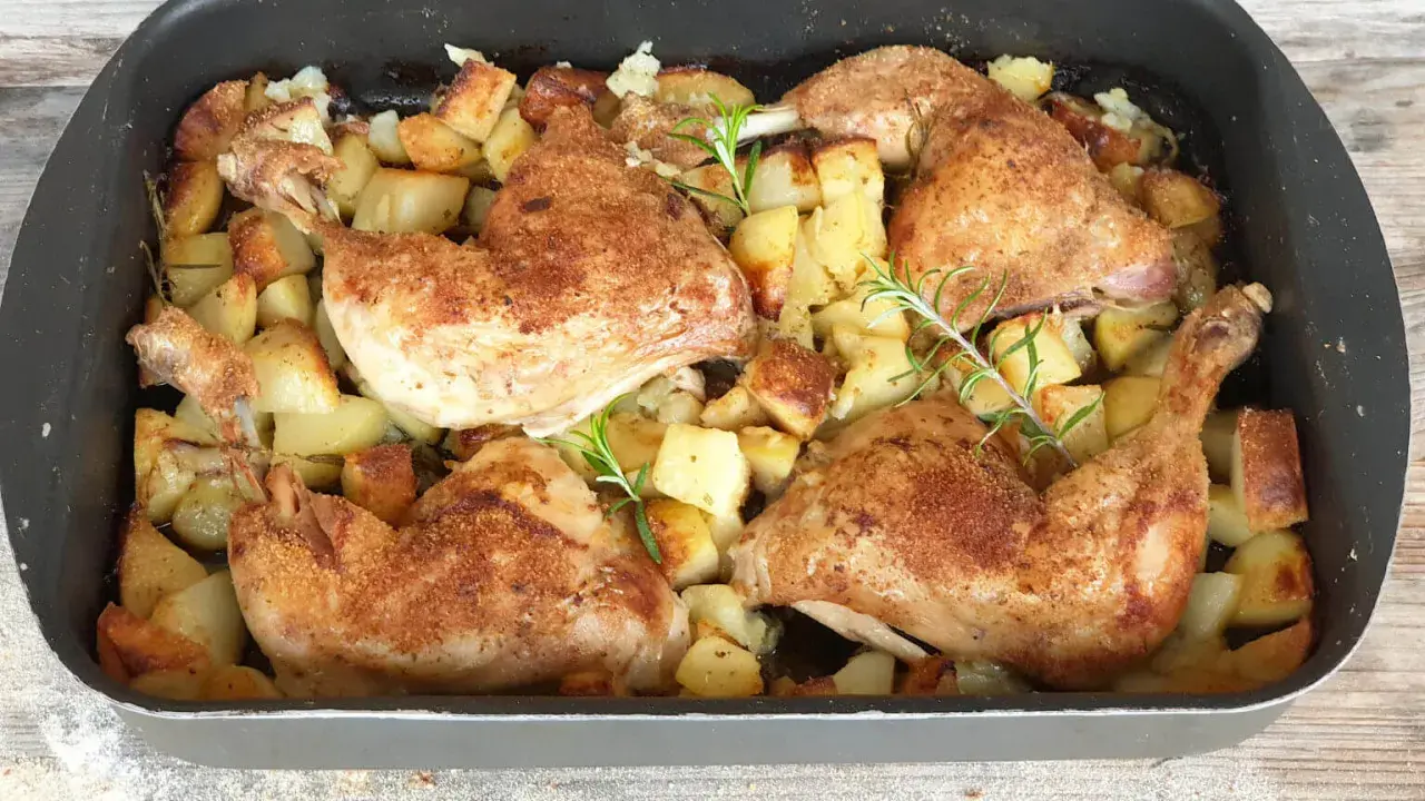 Succulento pollo al forno con patate dorate e rosmarino, pronto per essere gustato.