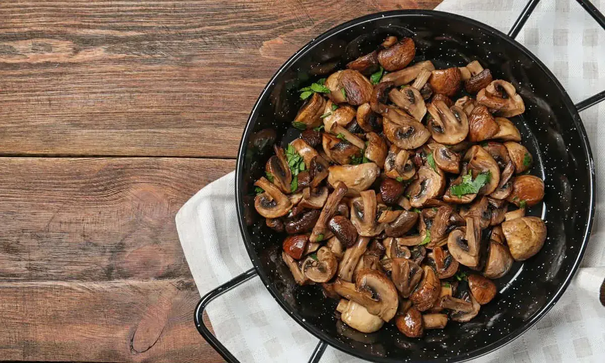 Funghi in padella, dorati e profumati, pronti per essere gustati.