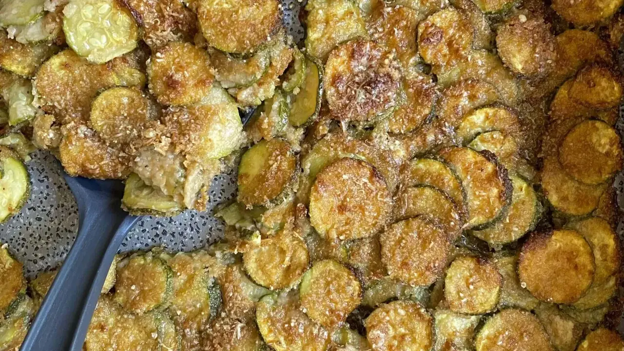 Fette di zucchine al forno dorate e croccanti, condite con parmigiano e pangrattato. Un contorno delizioso e facile da preparare.
