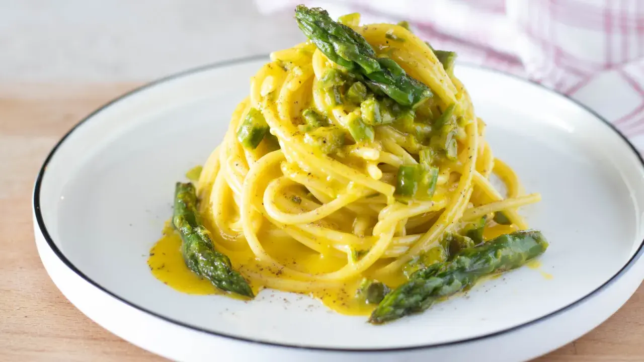 Spaghetti cremosi con asparagi, una deliziosa carbonara di asparagi, guarnita con punte verdi croccanti.