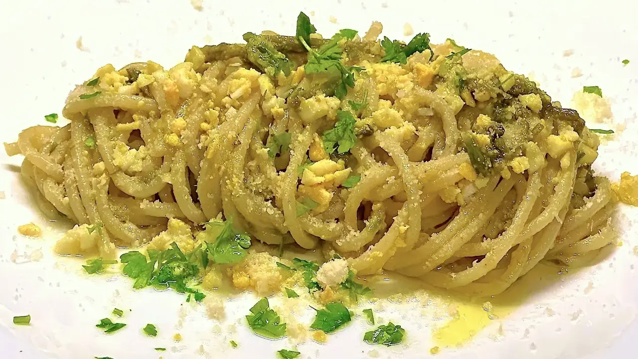 Un piatto di spaghetti con asparagi selvatici, uova sbriciolate e prezzemolo fresco. Un sapore di primavera in ogni boccone.