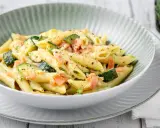 Penne con salmone e zucchine, un piatto cremoso e saporito, condito con erbe fresche e pepe nero.