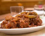 Un succulento piatto di coda alla vaccinara, cotta lentamente in un ricco sugo di pomodoro con verdure.