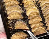Fette di melanzane al forno, dorate e croccanti, disposte su una teglia. Un contorno saporito e leggero.