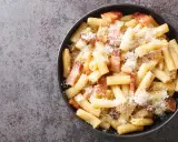Un piatto di pasta alla gricia fumante, con guanciale croccante e abbondante pecorino romano.