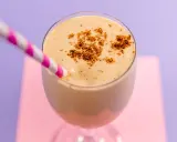 Delizioso spumone al caffè, guarnito con cacao in polvere, pronto da gustare con una cannuccia a righe rosa e bianche.
