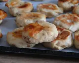 Deliziose polpette di pollo appena sfornate, dorate e con formaggio filante, pronte per essere gustate.