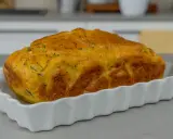 Sformato di zucchine dorato e soffice, appena sfornato, servito in una pirofila bianca.