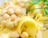 Piatto di ciceri e tria, pasta fresca con ceci cremosi e un rametto di prezzemolo.