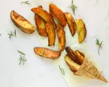 Patate al forno dorate e croccanti, guarnite con rametti di rosmarino fresco. Un piacere per gli occhi e per il palato.