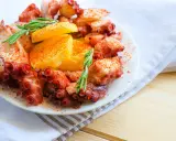 Un invitante polpo alla gallega, cosparso di paprika e guarnito con rosmarino e patate, pronto per essere gustato.