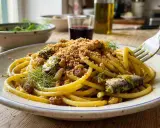 Un piatto di pasta con le sarde, condita con finocchietto selvatico, pinoli, uvetta e pangrattato croccante.