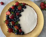Crostata di frutta fresca con fragole, mirtilli e ciliegie su una base dorata.