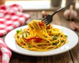 Un piatto di spaghetti alla carrettiera fumanti, conditi con pomodoro e prezzemolo, pronti per essere gustati.