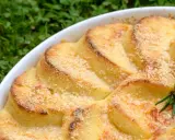 Gnocchi alla romana dorati e gratinati in una teglia bianca, con un rametto di rosmarino.