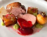 Piatto gourmet con filetto di maiale, patate croccanti, salsa rossa e guarnizioni verdi. Un'idea per le tue ricette di filetto di maiale.