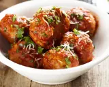 Polpette di carne morbide in salsa rossa, cosparse di parmigiano e prezzemolo fresco.