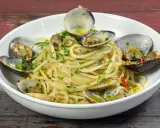 Spaghetti alle vongole surgelate, un piatto gustoso con pasta, vongole e prezzemolo.