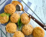 Polpette di merluzzo dorate e croccanti, guarnite con aneto fresco, pronte per essere servite.