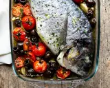Orata al forno con pomodorini e olive nere, un piatto saporito e profumato, pronto per essere gustato.