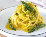 Spaghetti cremosi con asparagi, una deliziosa carbonara di asparagi, guarnita con punte verdi croccanti.