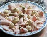 Vitello tonnato ricetta originale piemontese: fettine sottili di carne rosa, guarnite con salsa tonnata e capperi.