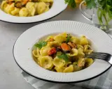 Orecchiette con patate e cozze, un piatto cremoso e saporito, guarnito con prezzemolo fresco.