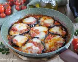 Melanzane alla pizzaiola in padella, con pomodoro e mozzarella filante, contornate da pomodorini freschi e basilico.