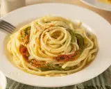 Un piatto di spaghetti conditi con delicati fiori di zucca, un classico della cucina italiana.