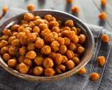 Ceci croccanti al forno, uno snack salutare e gustoso, serviti in una ciotola su un tovagliolo di lino.