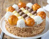 Torta Saint Honoré decorata con bignè caramellati, ciuffi di panna montata e crema pasticcera al cioccolato e vaniglia.