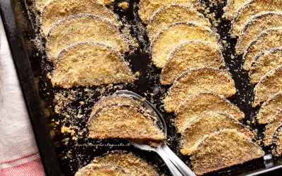 Fette di melanzane al forno, dorate e croccanti, disposte su una teglia. Un contorno saporito e leggero.