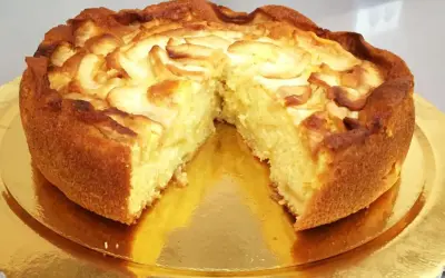 Una deliziosa torta di mele, dorata e soffice, con fette di mela disposte a spirale sulla superficie.