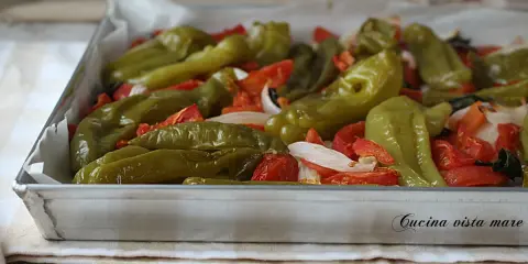 Friggitelli al forno con pomodori e cipolla, pronti per essere gustati.