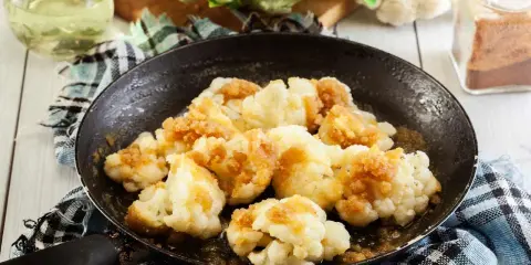 Cavolfiore in padella, dorato e saporito, pronto per essere gustato.