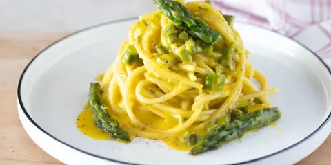 Spaghetti cremosi con asparagi, una deliziosa carbonara di asparagi, guarnita con punte verdi croccanti.