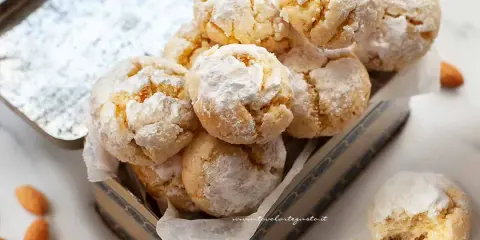 Biscotti con farina di mandorle, soffici e profumati, cosparsi di zucchero a velo, pronti per essere gustati.