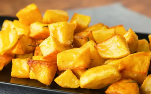 Un piatto invitante di patate al forno croccanti, dorate e saporite, pronte per essere gustate.
