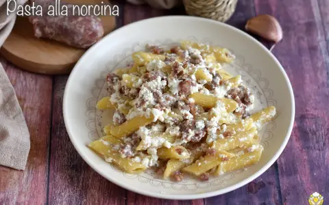 Piatto di pasta alla norcina con salsiccia sbriciolata e ricotta cremosa, un classico della cucina umbra.