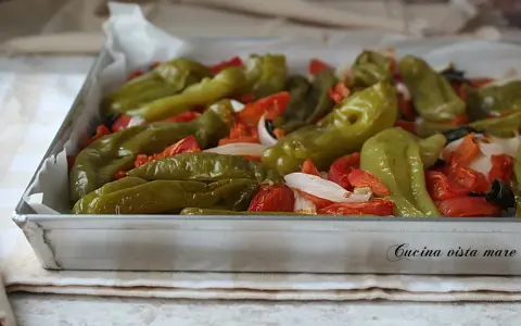 Friggitelli al forno con pomodori e cipolla, pronti per essere gustati.