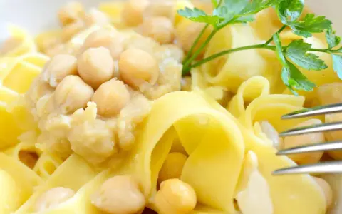 Piatto di ciceri e tria, pasta fresca con ceci cremosi e un rametto di prezzemolo.