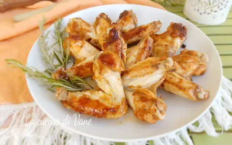 Alette di pollo in padella, dorate e succulente, guarnite con rosmarino fresco. Un piatto semplice e gustoso.